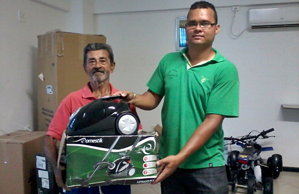 Um dos ganhadores recebendo um prêmio das mãos de um funcionário da empresa