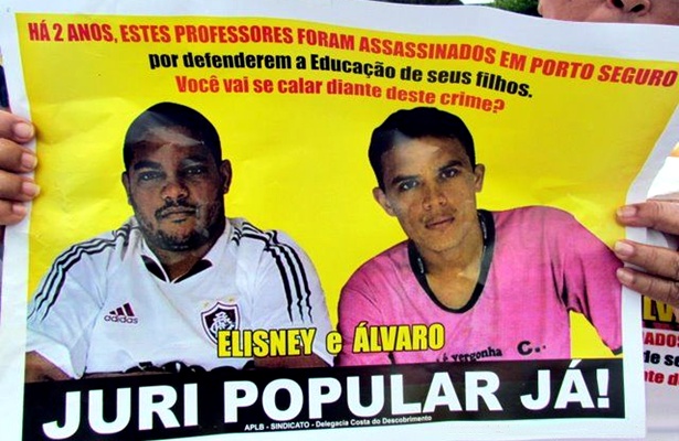 Cartazes com fotos dos professores mortos foram usados no protesto. Nos cartazes eram exibidos dizeres com pedidos de j&uacute;ri popular para os envolvidos nos crimes
