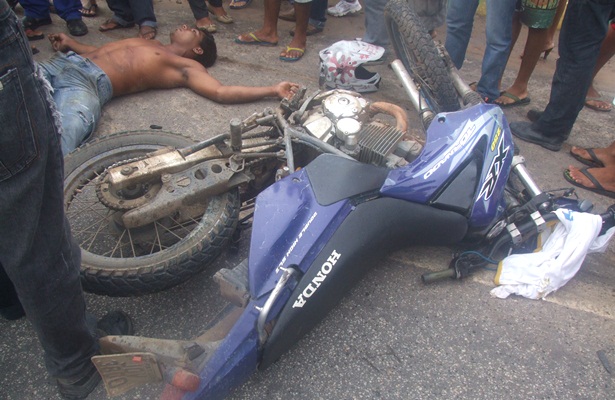 A v&iacute;tima fatal, Ualase, ainda vivo, ao lado da motocicleta, que ficou parcialmente destru&iacute;da