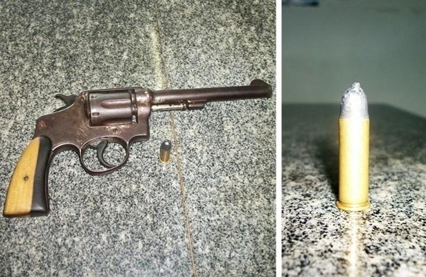 Arma apreendida com o elemento. Ao lado a muni&ccedil;&atilde;o com o formato adulterado
