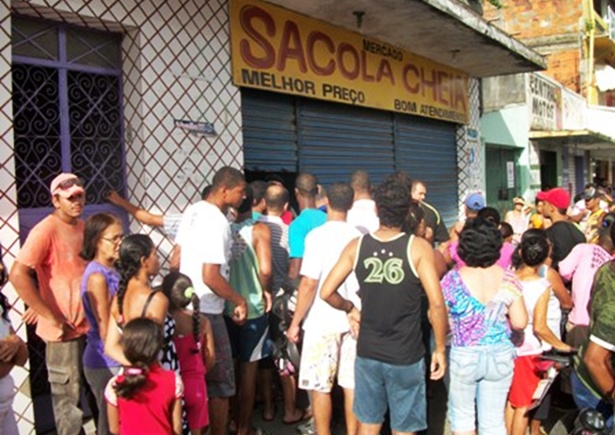 Várias pessoas se aglomeraram ma porta do supermercado onde ocorreu o crime.